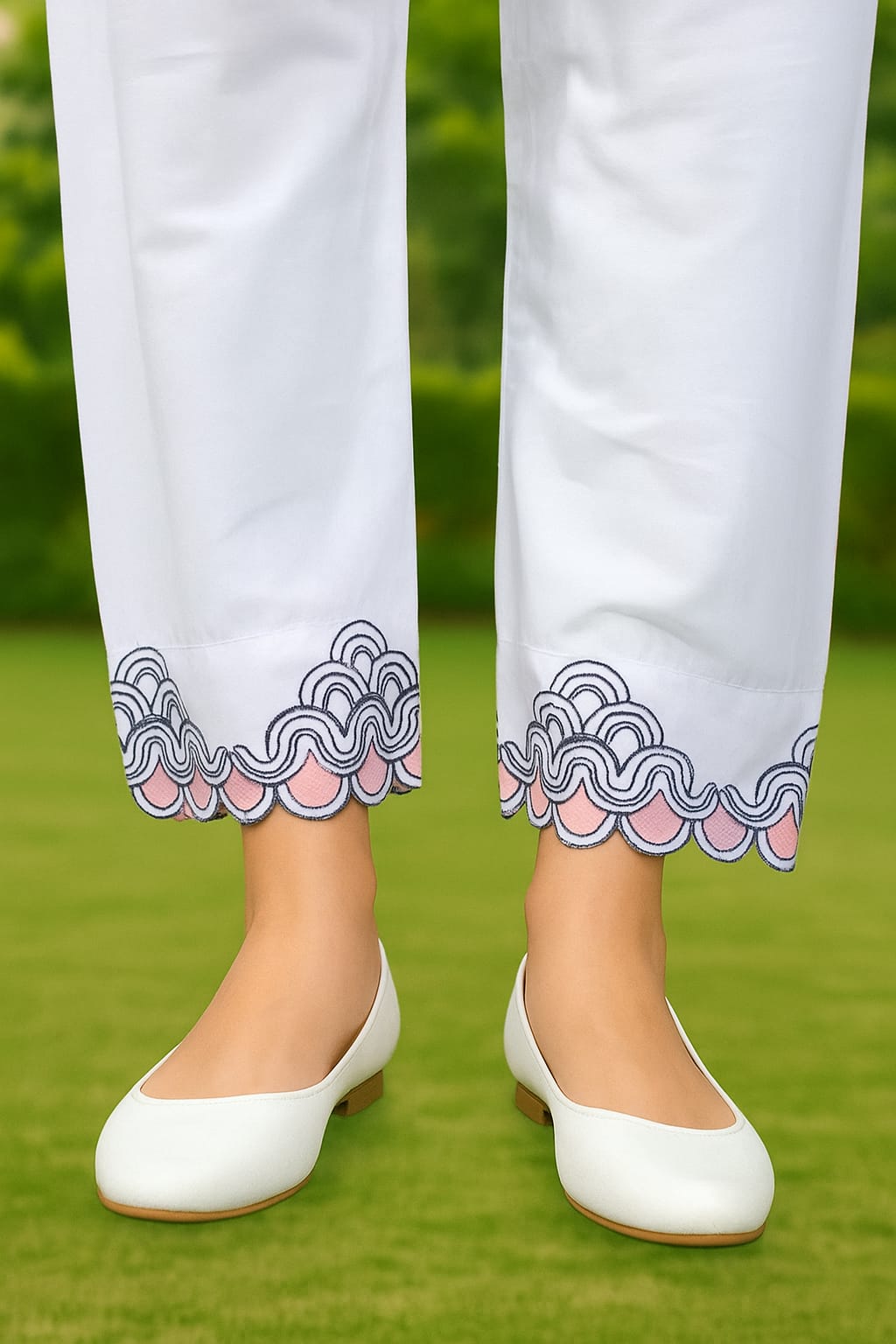 White pants with decorative hem and white shoes on a grassy background